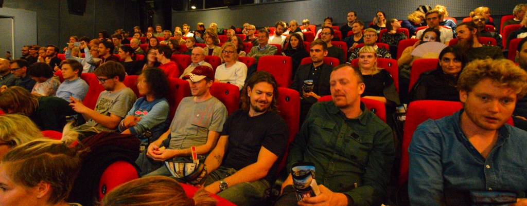 An audience straps in and clears their noses for the experience.