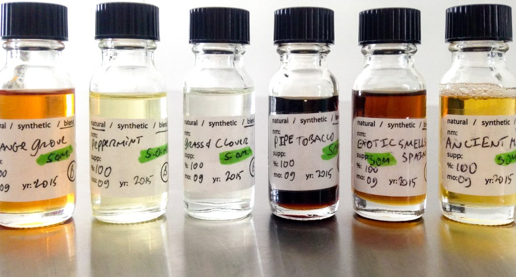 Several vials of fragrance side by side. From left to right: grove, peppermint, grass & clover, pipe tobacco, and exotic smells of Spain.